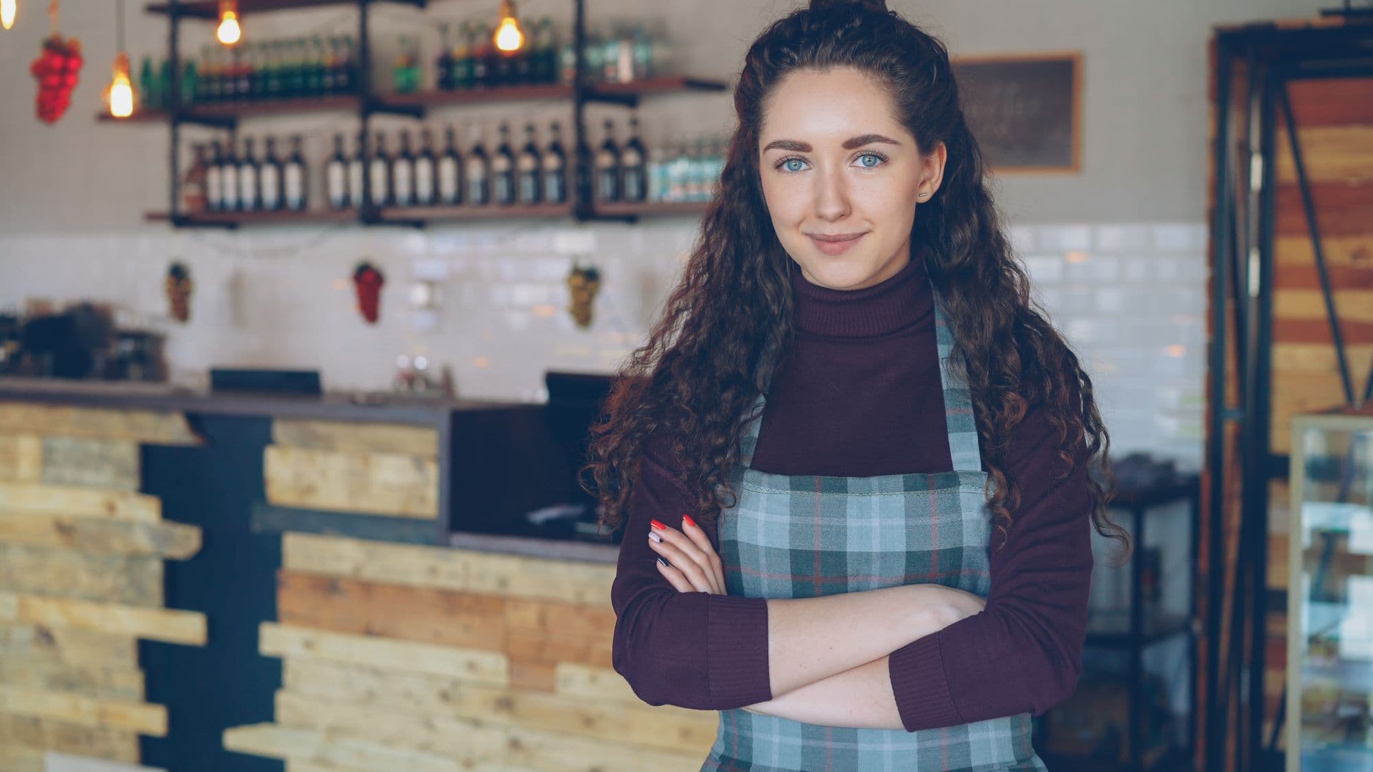 Restauratrice confiante, bras croisés, dans son établissement