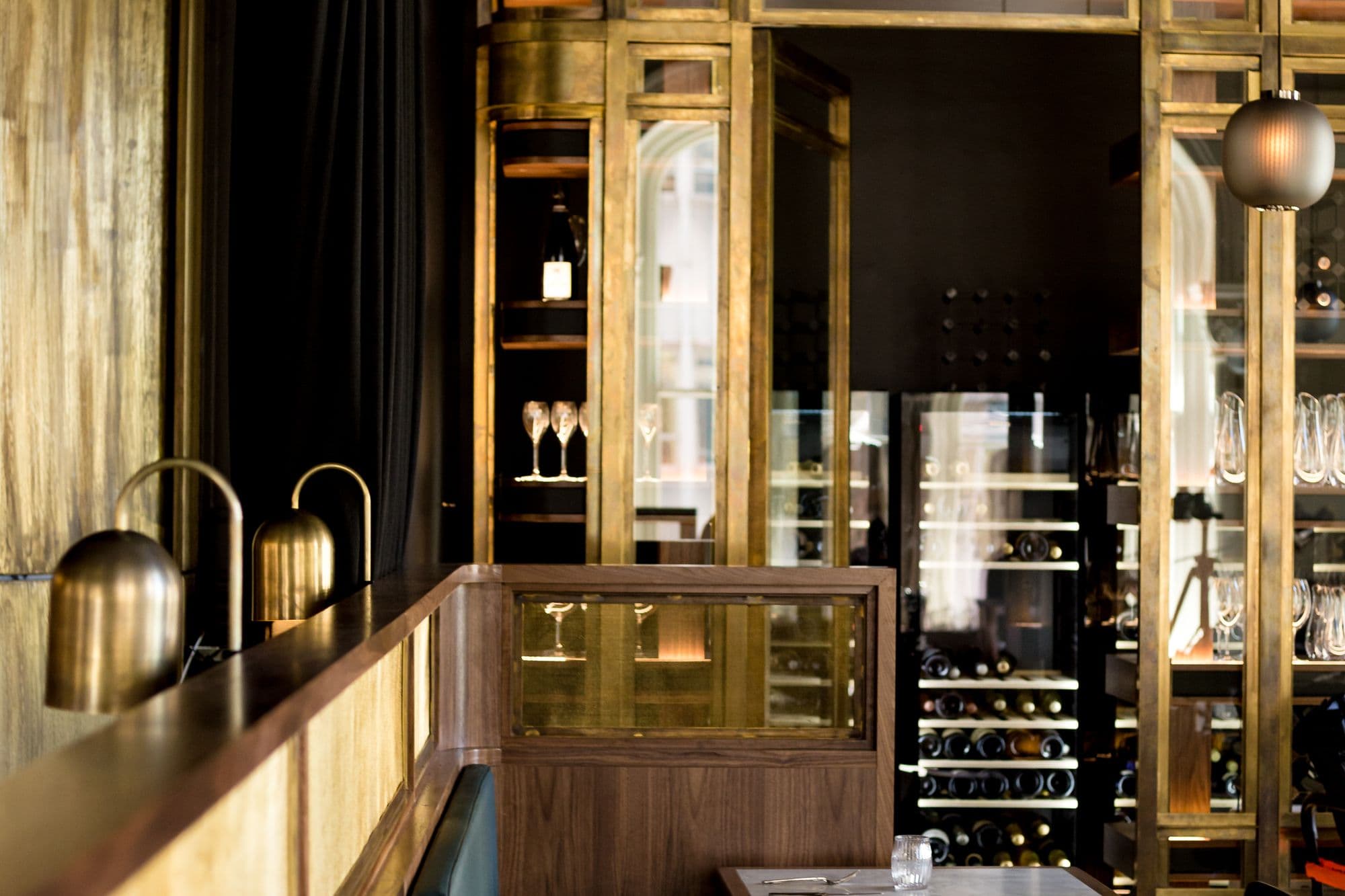 Cave à vin en laiton et bois d'une brasserie à l'éclairage chaleureux