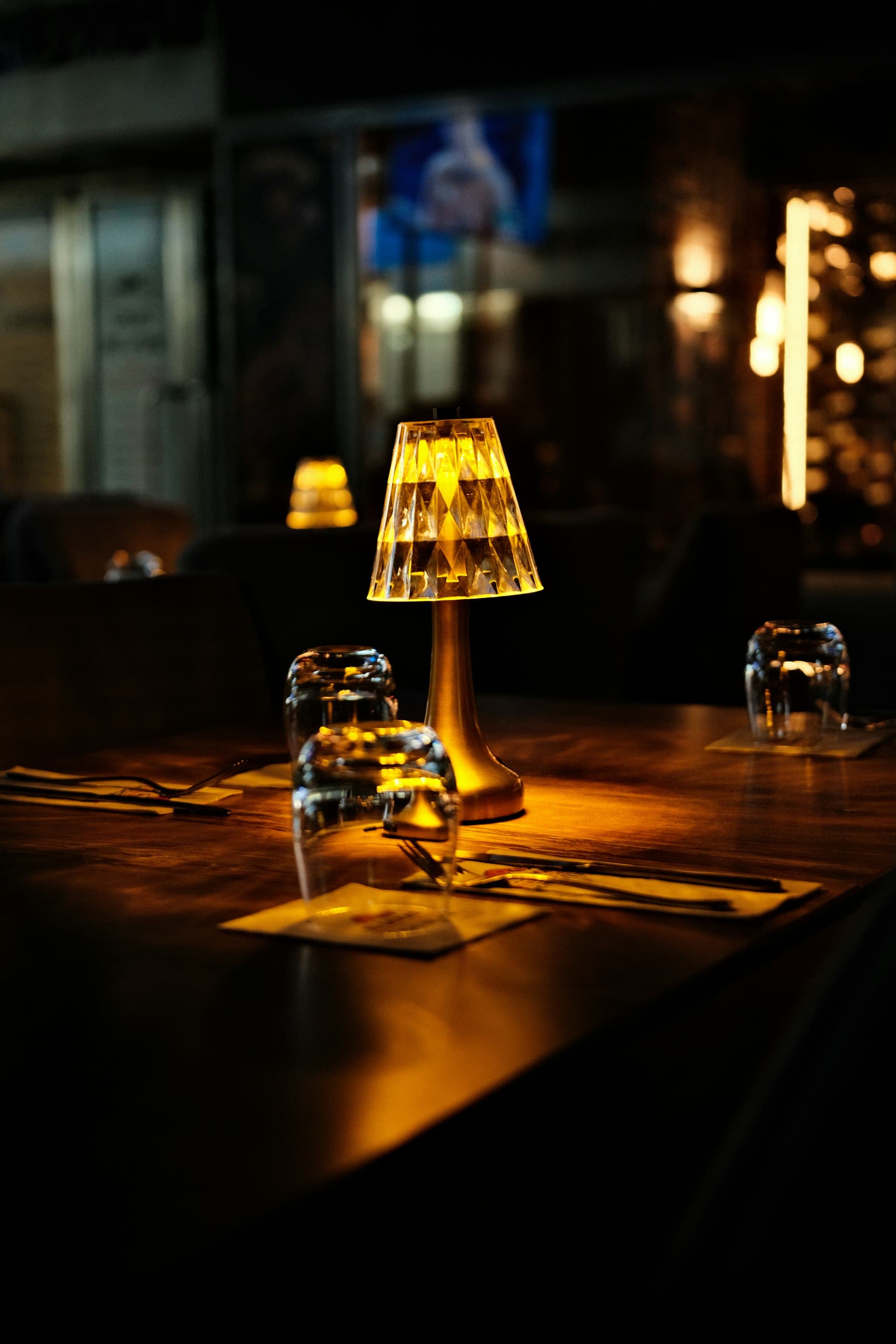Table de restaurant dressée avec une lampe d'ambiance, lumière chaude du soir